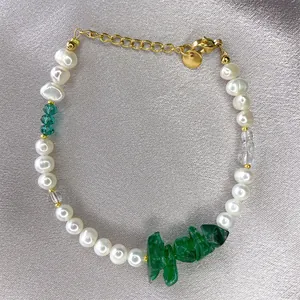 Detail of handmade bracelet with freshwater pearls, green stones and golden lobster clasp