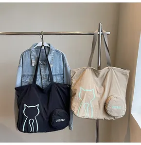 Detail of canvas tote bags with minimalist cat prints and round zipper pouches