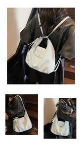 Close-up of light blue pleated shoulder bag with star charm and versatile strap design