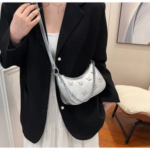 Silver crescent shoulder bag featuring 3D butterflies and a thick metal chain strap