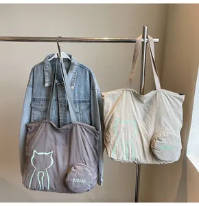 Detail of canvas tote bags with cat print, including matching round coin purse charm