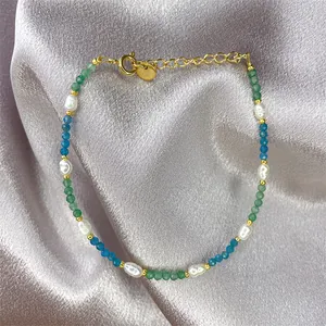 Detail of freshwater pearl and gemstone bracelet with golden lobster clasp and silk background