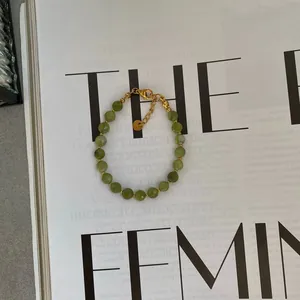 Collana minimalista con perline di pietra verde e chiusura in acciaio dorato con tag
