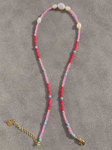 Close-up of multicolored natural stones and freshwater pearls with gold lobster clasp
