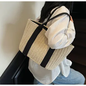 Detail der Textur der beige Strohtasche mit schwarzen Segeltuchriemen für den Strand