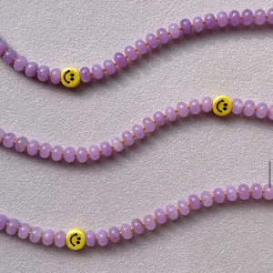 Collar de cuentas de calcedonia púrpura con separadores naranjas y cuentas de cara sonriente