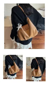 Detail of caramel PU leather tote bag with glossy finish and silver star charm
