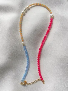 Macro detail of colorful beads with freshwater pearls on elegant silver satin fabric