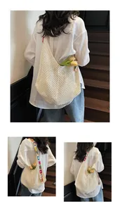 Detailansicht einer Häkel-Hobo-Tasche mit bunten, floral bestickten Schulterriemen
