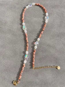 Macro view of natural stone, freshwater pearls, and petal beads on a beaded necklace