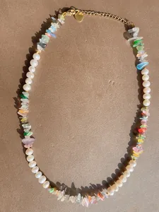 Detail of colorful gemstone beads with freshwater pearls and a gold heart pendant