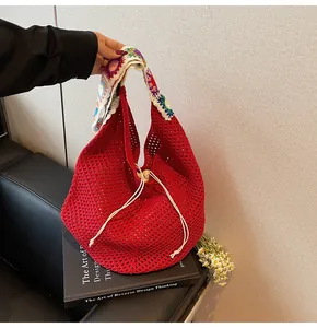 Detail der roten Häkeltasche mit buntem Blumen-Schultergurt und praktischem Kordelzugverschluss