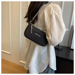 Detailed view of black nylon shoulder bag with silver chain strap shown on a model