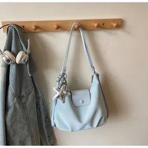 Close-up of light blue PU leather shoulder bag with a silver starfish charm detail