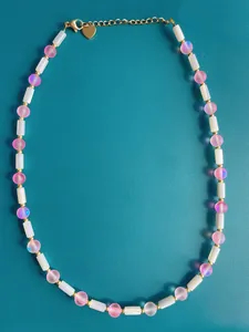 Close-up of handmade necklace with natural stones, freshwater pearls, and gold heart clasp