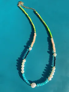 Detailansicht von Natursteinen und Süßwasserperlen an einer vergoldeten Edelstahlkette
