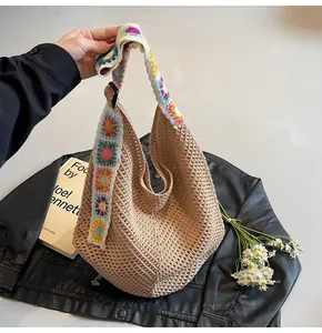Detail der handgewebten Strohtasche mit buntem Häkel-Regenbogen-Schultergurt
