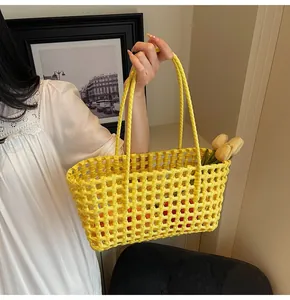 Detailed view of the yellow woven tote bag with a hollow grid texture and long top handles