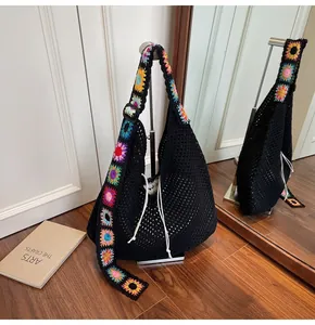Detail der schwarzen Häkeltasche mit bunten Sonnenblumen-Trägern und Kordelzugverschluss