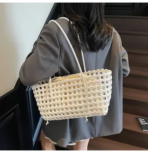 Detail of white woven hollow tote bag with a cream drawstring fabric inner lining