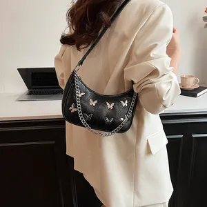 Chic black crescent underarm bag with silver butterfly charms and chain strap