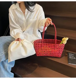 Chic red woven hollow basket bag with a white drawstring inner pouch on stairs