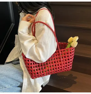 Detail of red woven tote bag featuring large mesh hollow design and glossy finish texture