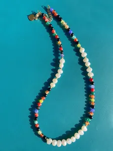 Detail of handmade necklace with colorful natural stones and freshwater pearls with gold clasp