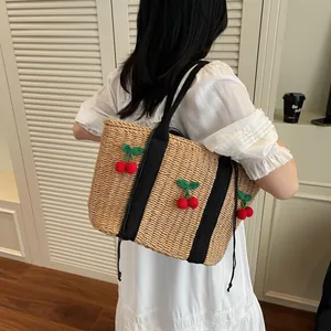 Minimalistische Stroh-Tote-Bag mit Kirsch-Strickornamenten und schwarzen Riemen