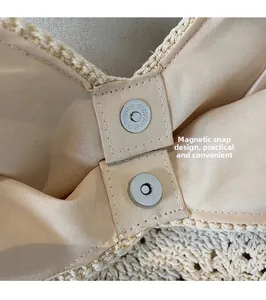Close-up of secure magnetic clasp on beige handwoven straw bag with fabric lining