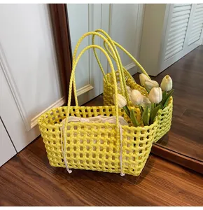 Detail of yellow woven basket bag with a white drawstring lining on a wooden floor