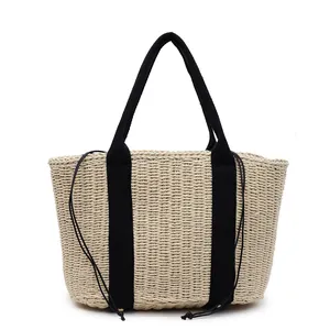 Schicke gewebte Strohtasche mit Kirschmuster und schwarzen Trägern für den Sommerurlaub