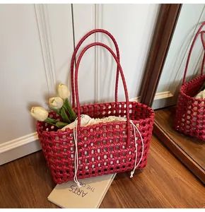 Close-up of red woven hobo bag featuring hollow mesh pattern and drawstring inner pouch