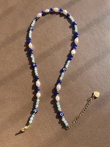 Detail von 18k vergoldetem Verschluss und Verlängerungskette mit blauen Evil-Eye-Perlen