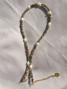 Close-up of handmade necklace with colorful natural stones and white freshwater pearls