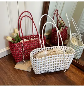 Detailed view of hand-woven tote bag showing the wide strap texture and inner drawstring pouch