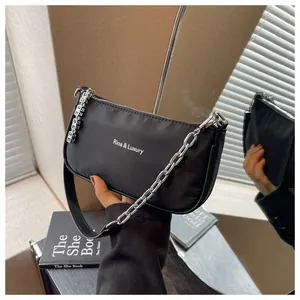 Close-up of black nylon shoulder bag with silver chain and Rioa & Luxury logo print