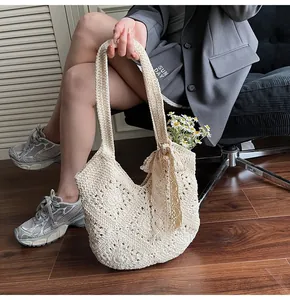 Close-up of cream woven crochet shoulder bag with bow detail and floral accents