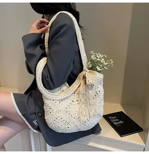 Detail of hand-woven beige tote bag featuring hollow geometric patterns and lace bow