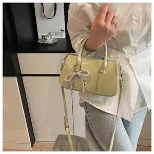 Detail der pistaziengrünen Ledertasche mit Perlenbogen und silbernen Beschlägen