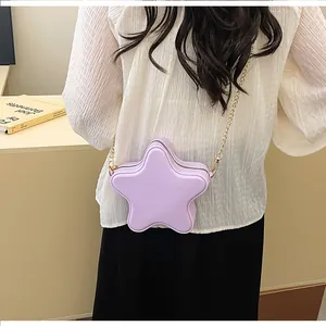 Détail d'un petit sac étoile violet avec chaîne porté par un mannequin en blanc