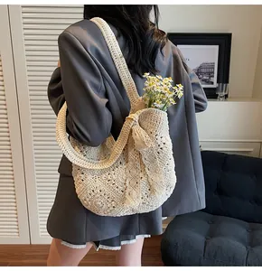 Detail of hand-woven shoulder bag with lace side tie and floral cutout patterns