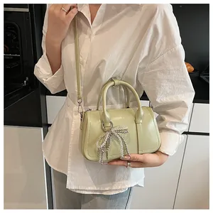 Detail der minzgrünen glänzenden Boston-Tasche mit Perlenbogen und Silberbeschlägen