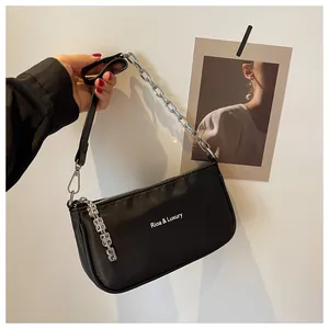 Detail of black nylon shoulder bag with silver chain strap and brand lettering logo