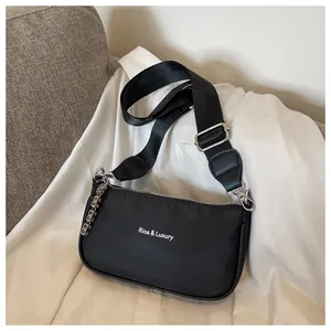 Detail view of the luxury black nylon shoulder bag with signature white logo lettering