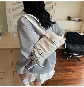 Detail of white glossy pleated shoulder bag featuring a silver star charm and buckle
