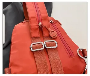Detail view of the reinforced orange nylon strap with adjustable metal buckle and zipper