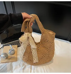 Detail of hand-woven straw bag with lace bow and hollow floral crochet patterns