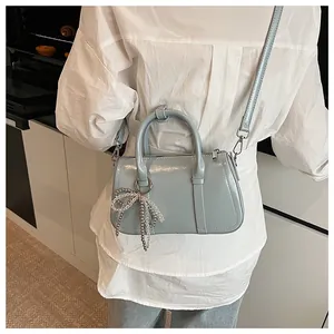 Detail der hellblauen Lackleder-Boston-Tasche mit Perlenbogen und Umhängeriemen