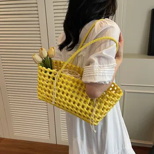 Yellow woven hollow-out handbag with a cream drawstring pouch for summer beach outings